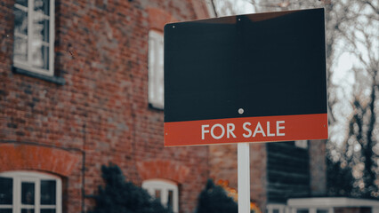 Obraz premium for sale sign placed in front of a traditional English house, symbolizing real estate opportunities