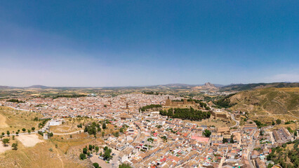 Panoramic aerial view of Antequera City. View of Antequera's castle with "Pe&ntilde;a de los Enamorados" mountain in background. Clear blue sky. Famous travel destination in Spain, Andalucia.