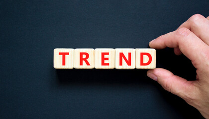 Trend and trending symbol. Concept word Trend on beautiful wooden blocks. Beautiful black table black background. Businessman hand. Business lifestyle trend and trending concept. Copy space.