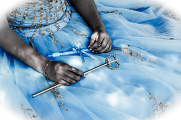 Young girl, in a bright blue dress, holding objects