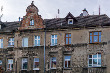 facade of an old shabby and dilapidated residential building in the city. cheap apartments for rent and for purchase in old buildings. old urban architecture.