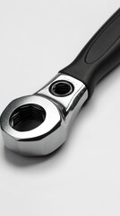 Obraz premium Close-up view of a metallic ratchet wrench with a black handle against a white background