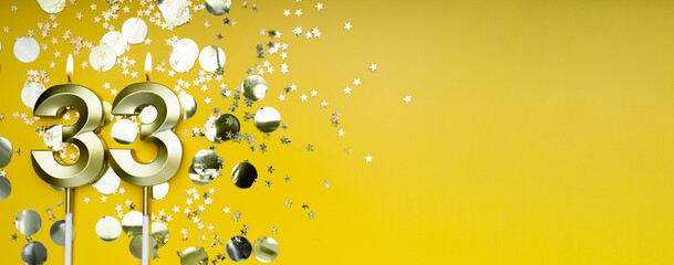 Golden candle number thirty-three on yellow background. Birthday card with lettering 33....