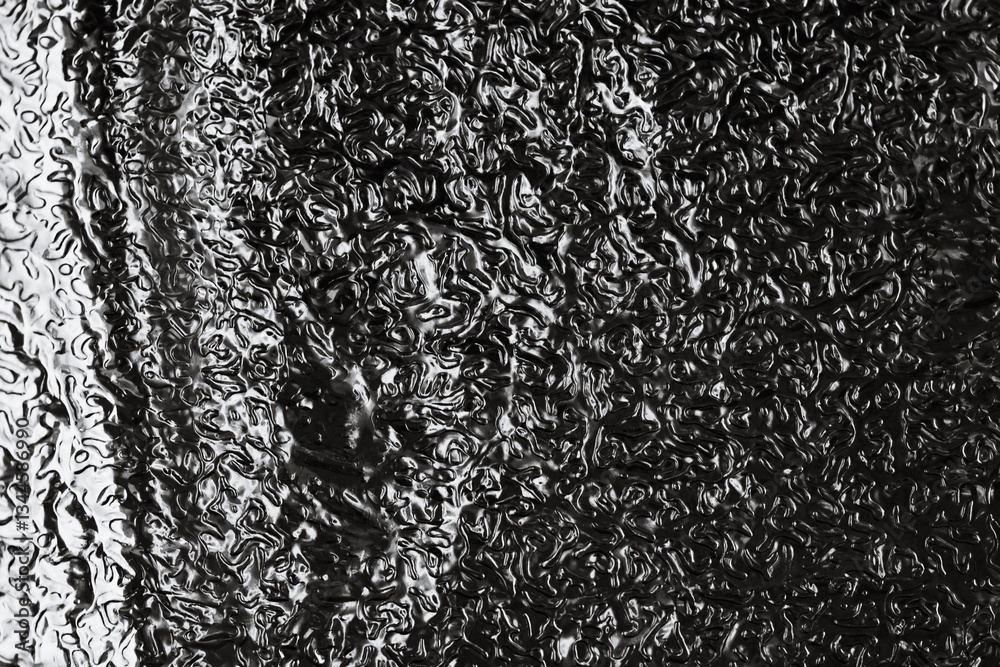 Poster water droplets on a window with a reflective surface.