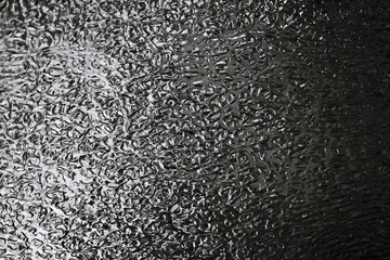 A black and white photo of a frosty surface.