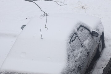 A car stuck in the snow, ideal for winter scenes or cold weather contexts.