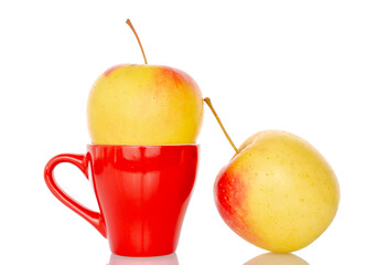 Two juicy apples with red ceramic cup, macro, isolated on white background.