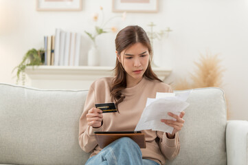 Asian woman feeling unhappy after looking bill feels stressed having financial problem, check finances, experiencing lack of money pay for loan, huge taxes, utility rates, get eviction notice