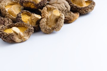 A refined view of dried shiitake mushrooms on white, with rich textures and subtle, earthy tones.