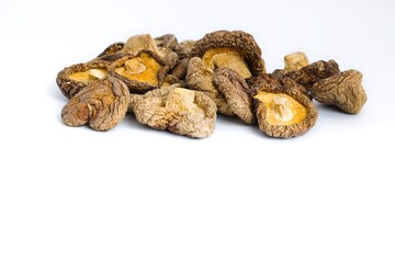 Neatly arranged dried shiitake mushrooms on a white backdrop, offering a glimpse of their rustic, earthy character.