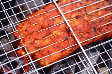 Meat cooking on a grill, sizzling hot and juicy.