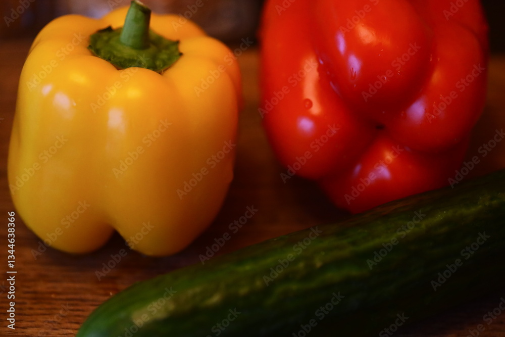 Poster A simple still life of two peppers and a cucumber arranged on a table.