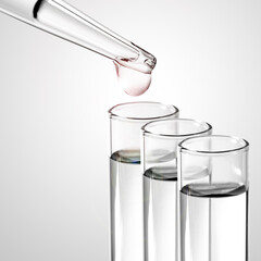 Liquid drop from laboratory glass pipette to test tube