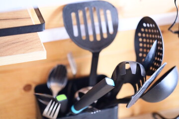 Container filled with various kitchen utensils.