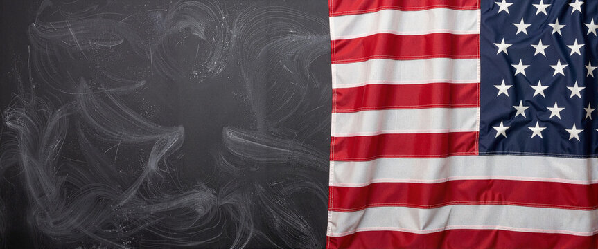 Worn American flag draped over blank chalkboard, patriotic symbolism