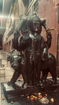 bronze statue of Shani Dev, Hindu god of India, at night in temple.