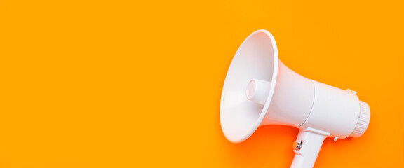 White megaphone on solid orange background, attention announcement concept
