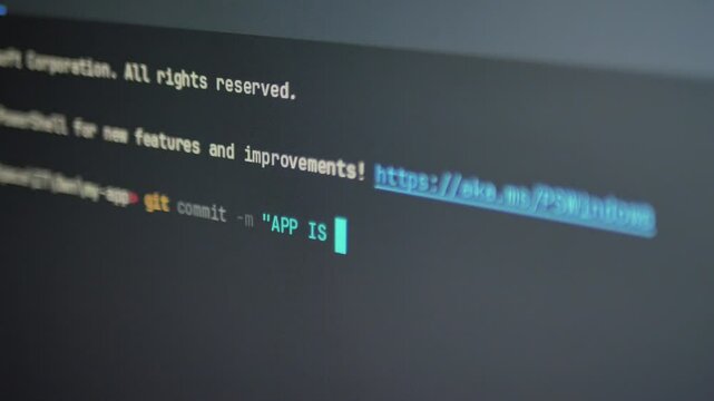 A close-up shot of a computer screen displaying a developer typing the Git commit command to finalize an application update in a terminal. Typing "App is done"