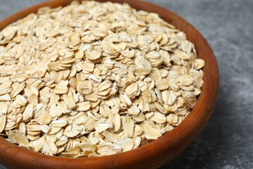 Composition with oatmeal flakes on gray background. Cooking breakfast