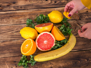 Hands taking citrus fruits from table.
