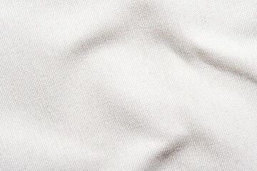 Close-up of textured white fabric with natural light and soft shadows.