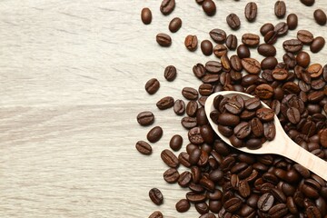 Wooden spoon with coffee beans on wooden background