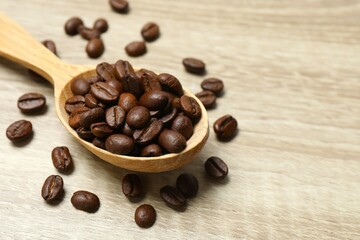 Wooden spoon with coffee beans on wooden background