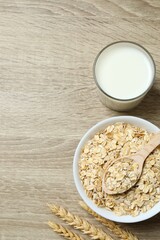 Composition with oatmeal flakes on wooden background. Cooking breakfast