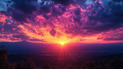 Obraz premium Vibrant sunset over mountains and city, colorful clouds.