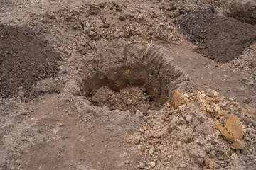 A round hole dug in the ground for planting trees in the spring. Garden preparation and planning