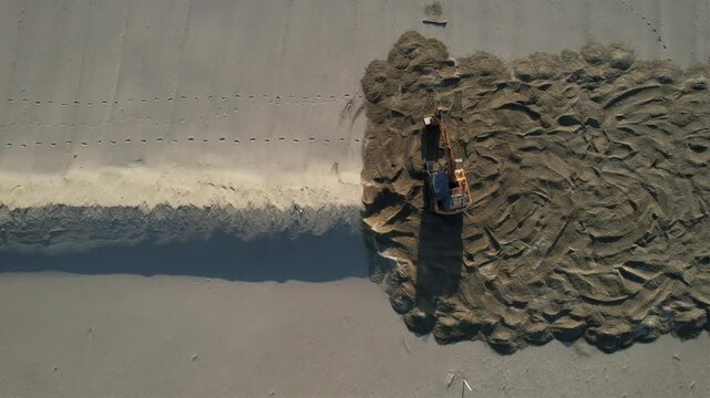 Bulldozer in Versilia, removal of storm surge protection, aerial video documentation.