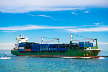 Freight container loaded on cargo vessel. View of cargo ship navigating the sea leaving or entering...