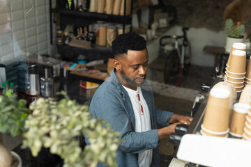 Barista preparing coffee at cafe, focused on making perfect espresso, copy space