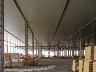 Obraz premium Inside a vast commercial construction site, structural steel and concrete form the emerging building's skeleton.