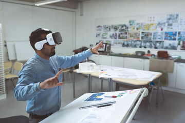 Man using VR headset in office, interacting with virtual design project, copy space