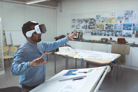 Man using VR headset in office, interacting with virtual design project, copy space
