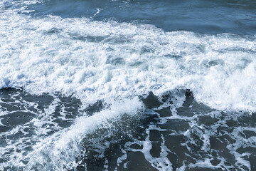 Ocean waves surging with foam against the shore