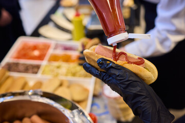 Staff Members Preparing a Delicious Hot Dog with Ketchup at the Event Taking Place