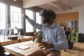 African American man using VR headset in modern office, exploring virtual world, copy space