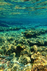Underwater seascape with colorful stones, rich blue color ocean. Sea with rocky landscape, underwater photography from snorkeling. Sea and stones, travel picture.