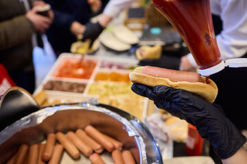 Staff Members Preparing a Delicious Hot Dog with Ketchup at the Event Taking Place