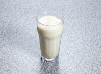 Homemade soy milk served in glass dish isolated on stone background side view of Asian Hong Kong...