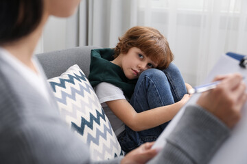 Little boy having therapy session with psychologist in office