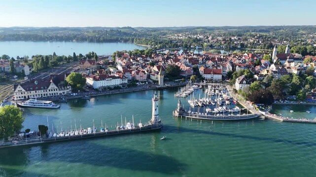 Pan shot of panorama view of Harbour entrance with lighthouse and Bavarian Lion sculpture on island Lindau at Lake Constance (Bodensee) in Germany