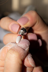 Nail Technician Using Electric Nail Drill for Manicure and Nail Care