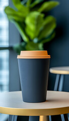 Dark gray disposable coffee cup with lid on a small table