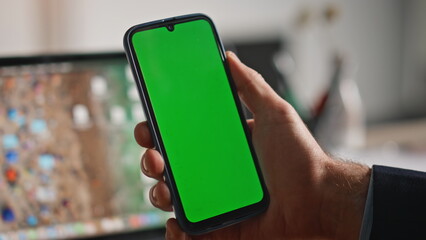 Businessman hand swiping mockup mobile phone working at laptop workplace closeup