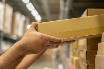 Closeup hands picking up products box paper on shelf. Customers picking up items on shelves....