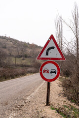 Sharp Curve and No Overtaking Road Sign
