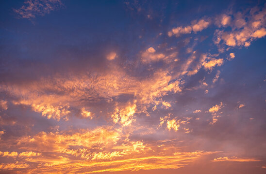 Sky clouds sunset background. Stunning view of golden, lilac and pink clouds and blue sky